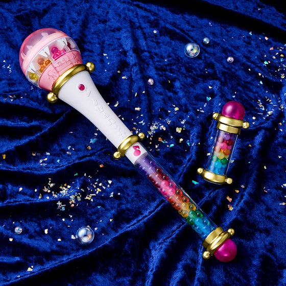 A multicolored magical wand instrument from the anime Ojamajo DoReMi, known as Kururu Pollon, with interchangeable beads and a button on the top handle.