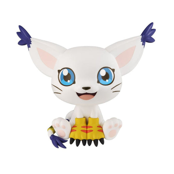 Two 'Digimon' character figures, Agumon in yellow and Tailmon in white, posed sitting with their heads slightly turned to the side, held in hands against a neutral background.